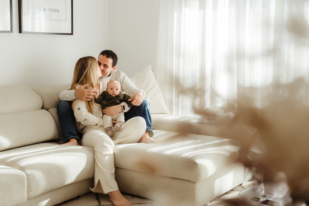 papa y mama en sofa con su bebé