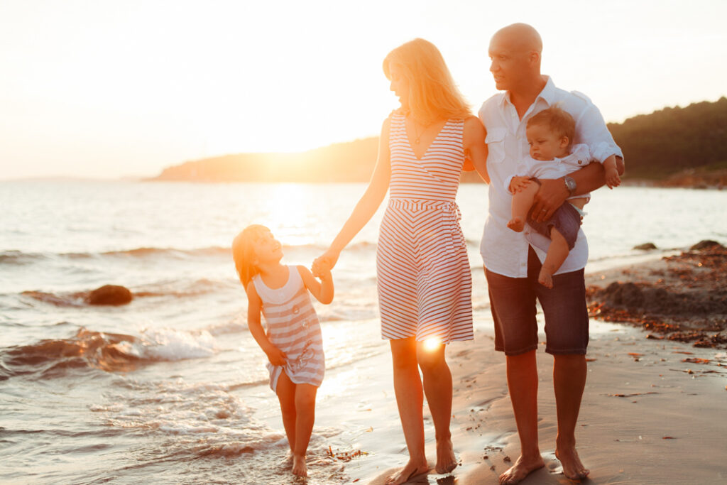 FAMILIA CAMINANDO POR LA PLAYA CON PUESTA DE SOL ESPECTACULAR